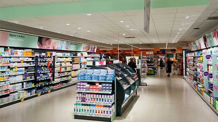 A boa iluminação dos corredores orienta um cliente através da loja nos Supermercados Consum, Valência