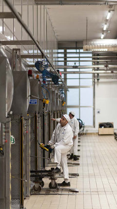 Homens a trabalhar na fábrica da Hero em Espanha, que é iluminada pela iluminação economizada LED Philips