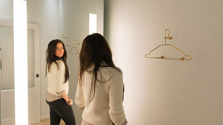 Uma cliente da SuperTrash vê o seu reflexo no Espelho AmbiScene da Philips, na definição de luz “Dia”