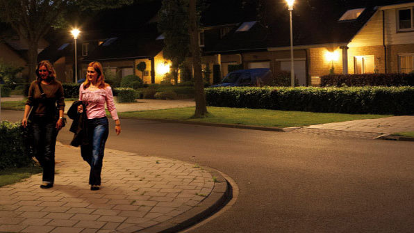 Duas mulheres a caminhar numa rua iluminada com luz branca Philips