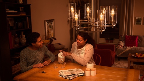 Duas pessoas sentadas no sofá em casa a desfrutar de luz LED de alta qualidade