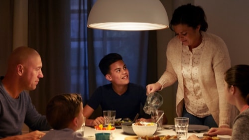 Família a jantar em casa numa mesa de jantar bem iluminada