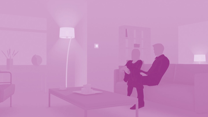 Visualização de um casal sentado no sofá em casa a desfrutar de iluminação LED