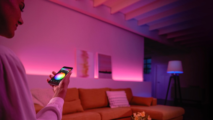 Pessoa a controlar luzes coloridas na sala de estar