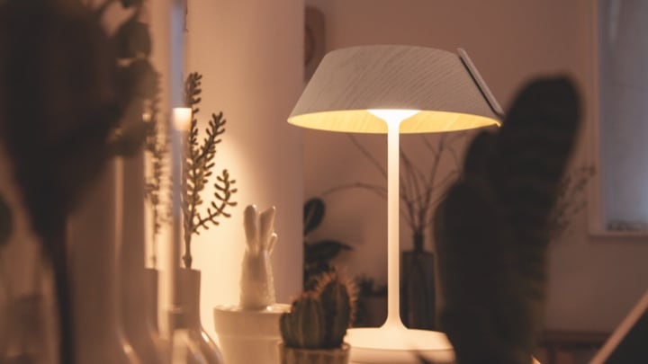 Candeeiro de mesa a iluminar um armário da sala de estar