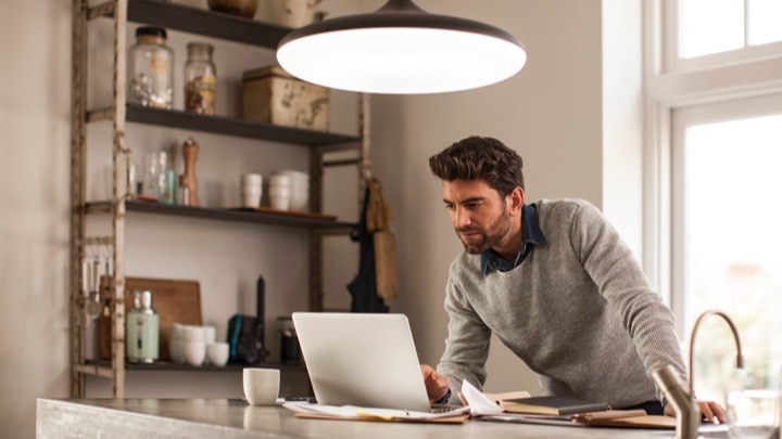 Um homem a trabalhar em casa sob uma luminária inteligente