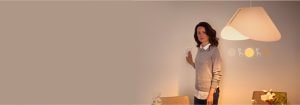 "Mulher ajustando o interruptor dimmer inteligente, que controla o ambiente de iluminação LED quente num espaço de vida contemporâneo com decoração minimalista"