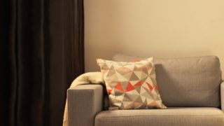 "Sala de estar acolhedora com candeeiro de mesa LED moderno, iluminando o sofá-cama cinzento e criando um ambiente acolhedor para relaxar na Habitação."